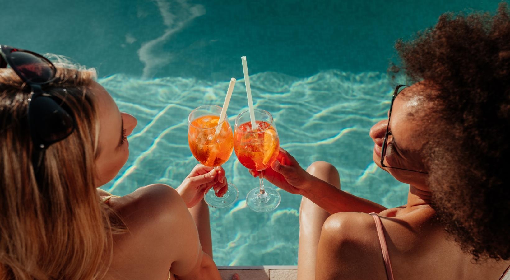 Relax and unwind poolside a man and woman drinking from glasses