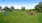 a grassy area with a playground in the background