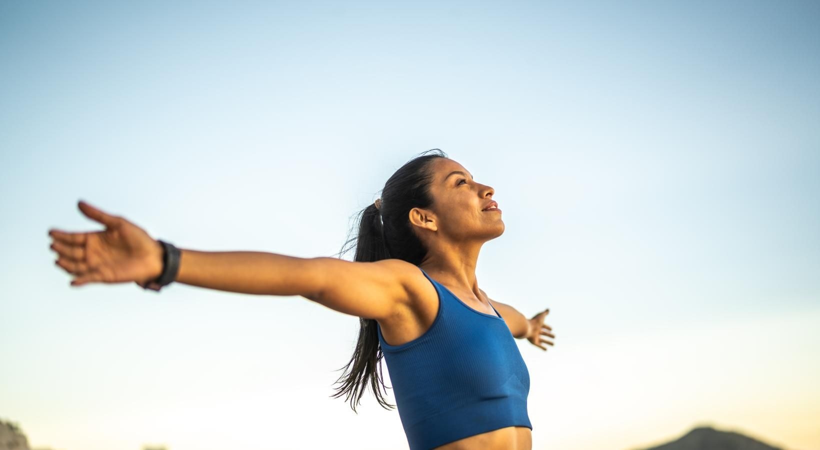 The essence of exceptional living a woman in a blue leotard with her arms out
