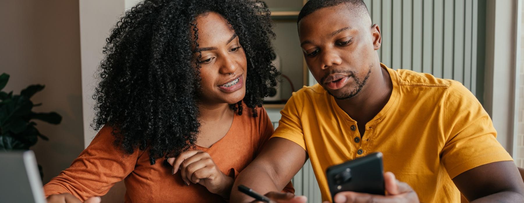 a man and a woman looking at a phone